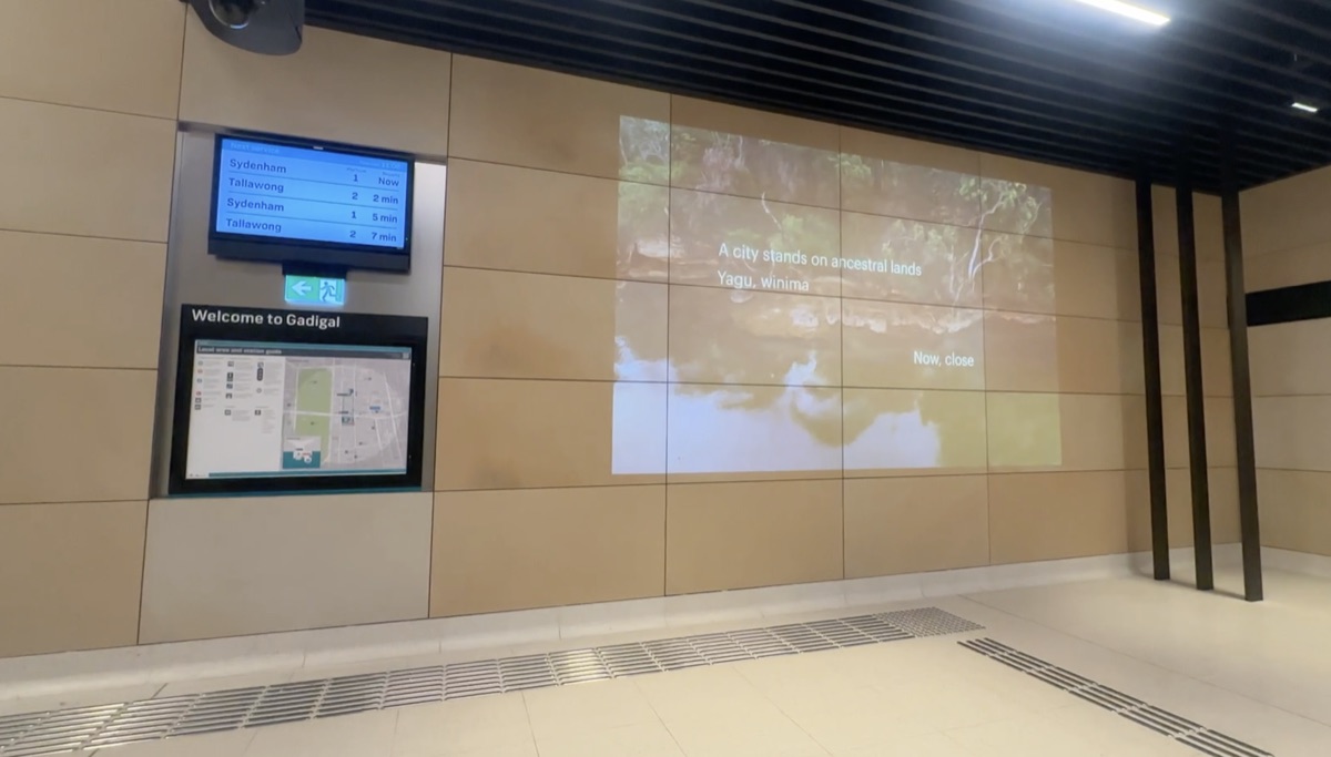 Projection at Gadigal Metro Station reading 'A city stands on ancestral lands, Yagu, winima'